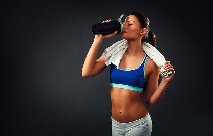 A woman in good shape uses a drink to burn fat